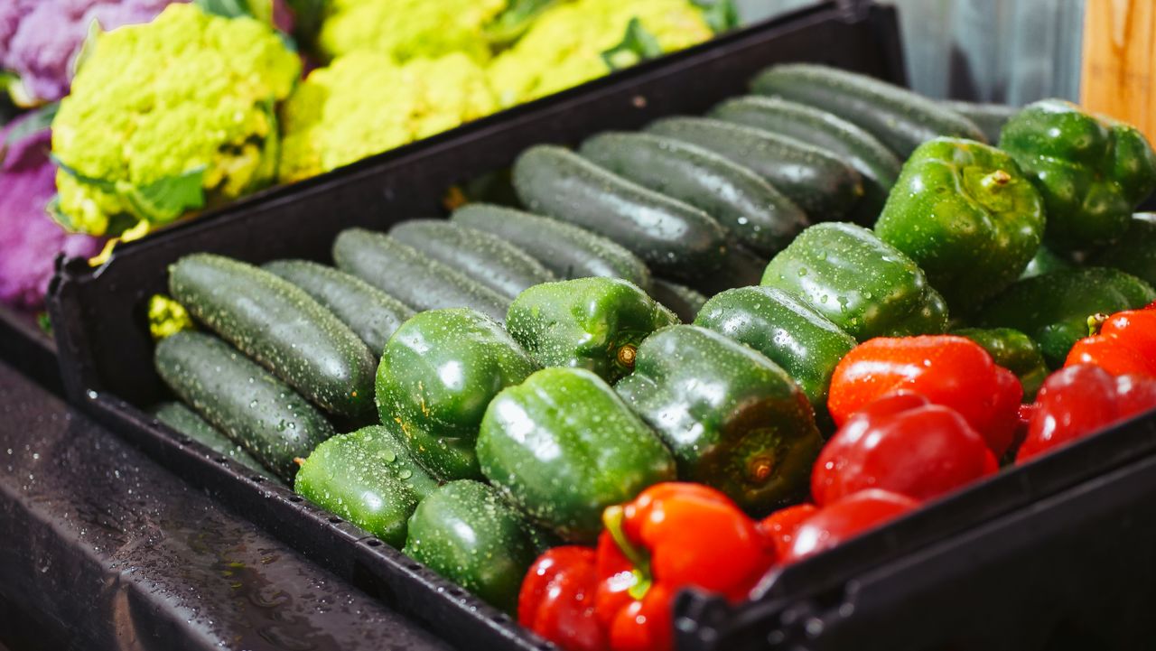 Vibrant bell peppers and zucchinis on display, showcasing freshness.